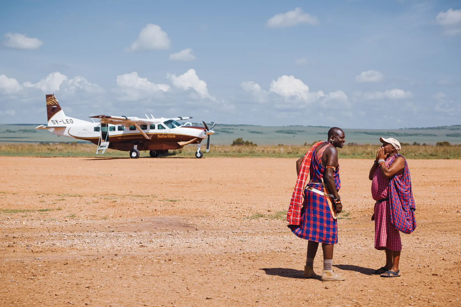 Two Maasai men beside a light aircraft on a bush airstrip