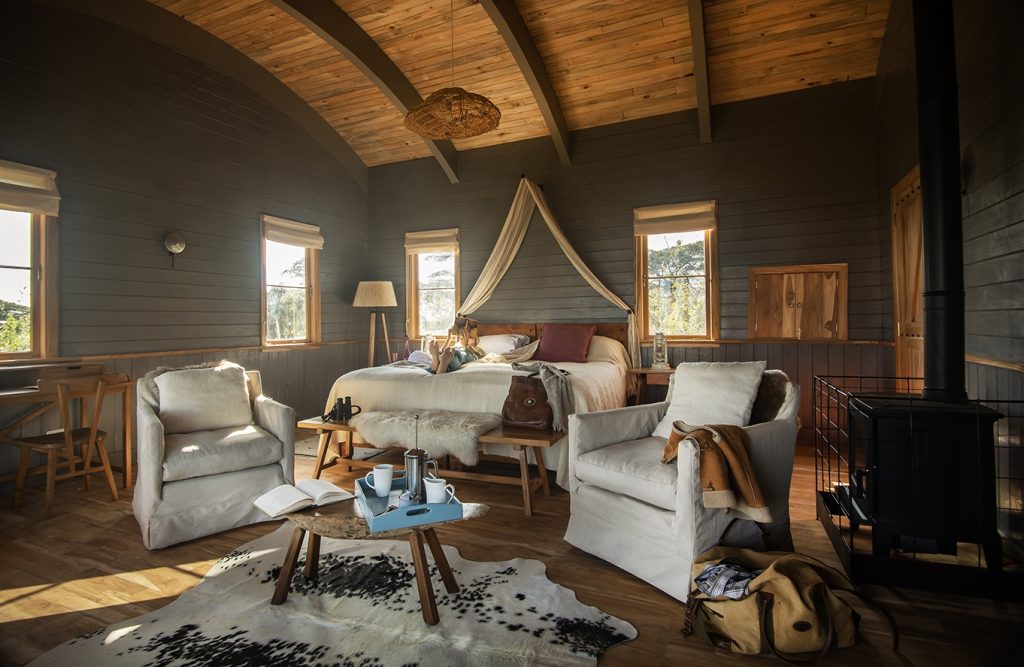 Entamanu Ngorongoro: Bedroom at main camp with canopy bed, armchairs and wood-burner