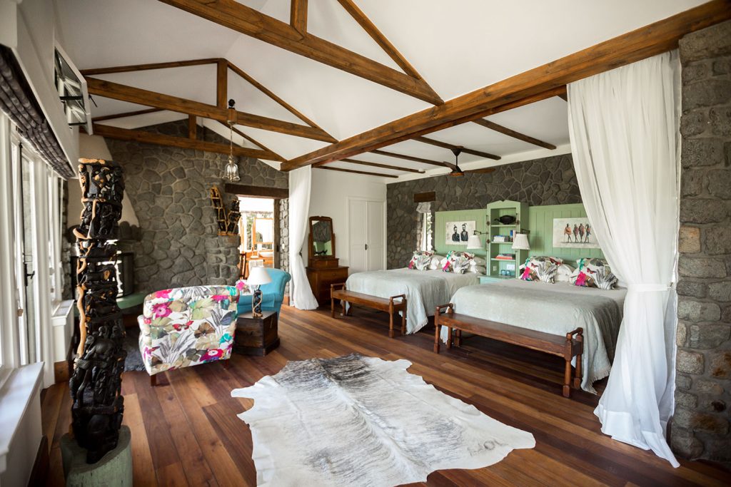 Gibb's Farm: Farm cottage bedroom with twin beds, stone wall, eucalyptus floors and hand-crafted furniture