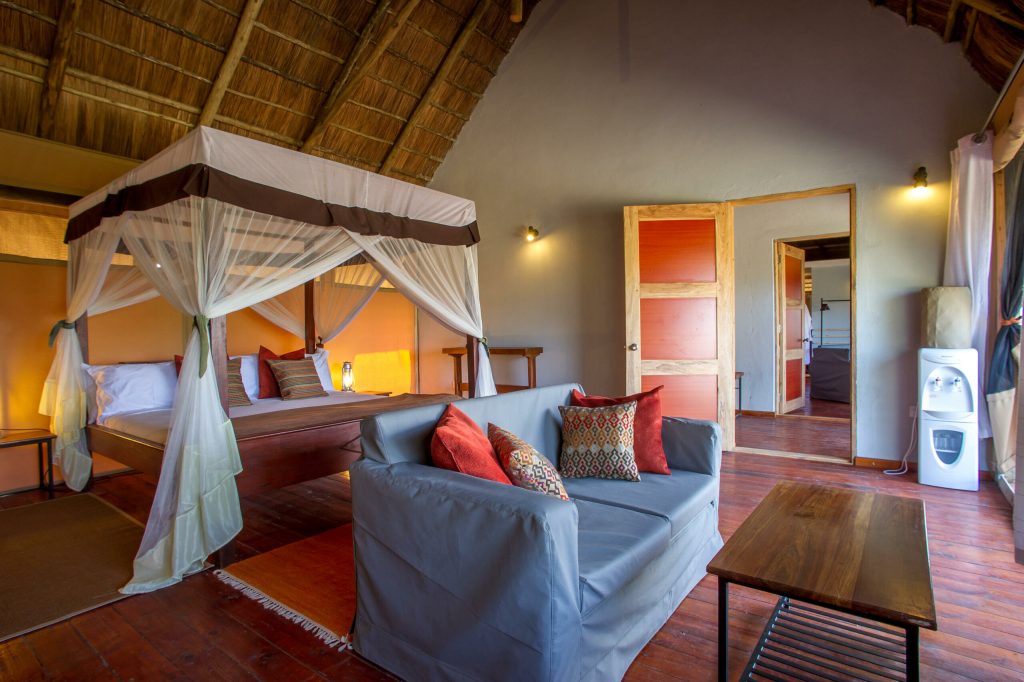 Masek Tented Lodge: Suite tent interior: canopy bed, sofa, bathroom doorway