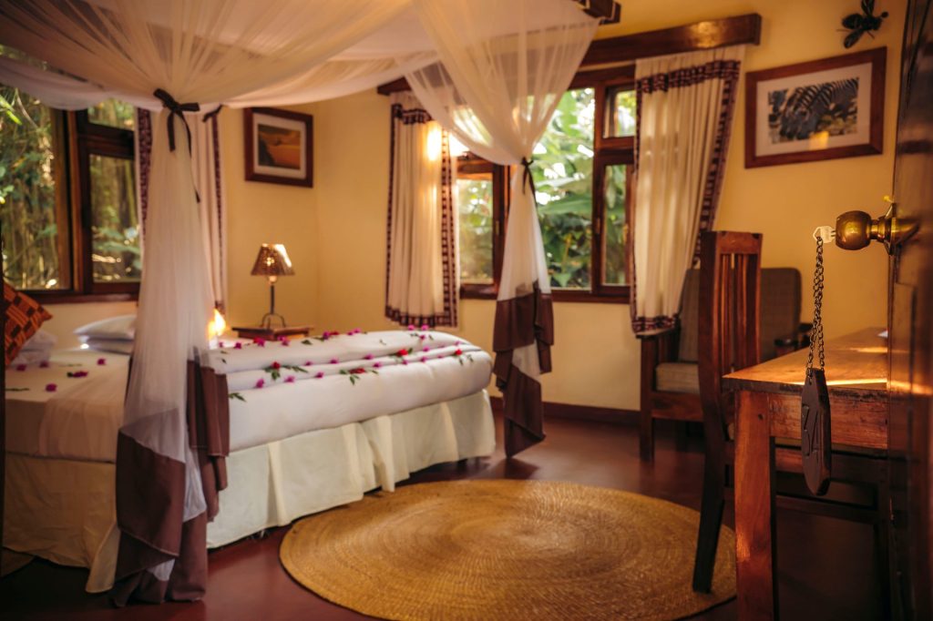 Moivaro Lodge: Cottage bedroom with canopy bed and warm lighting