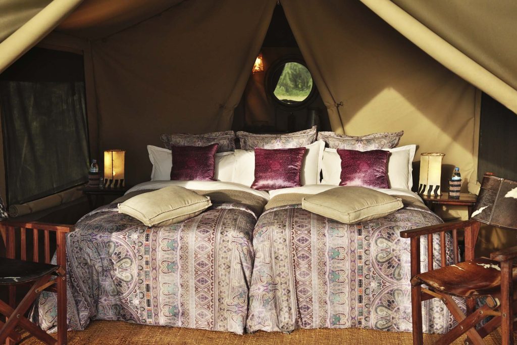 Pakulala Safari Camp: Tent interior with two queen beds, patterned throws and bedside lanterns
