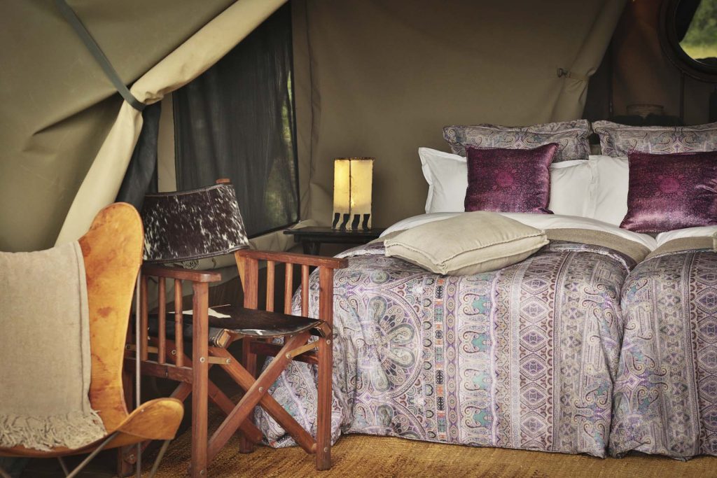 Pakulala Safari Camp: Tent interior detail: bed, leather safari chair and lamp
