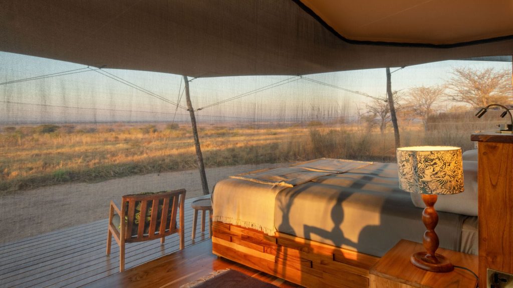 Usangu Expedition Camp: Guest bedroom interior: bed facing wide views of Ruaha through mesh walls